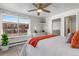 Bright bedroom with large window, dresser, modern ceiling fan, and ensuite bathroom at 1315 Estes St # 13C, Denver, CO 80215