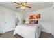 Bright bedroom featuring a ceiling fan, wood floors, and a door to the bathroom at 1315 Estes St # 13C, Denver, CO 80215