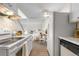 Bright kitchen with white appliances and cabinets, connecting to the dining area at 1315 Estes St # 13C, Denver, CO 80215