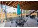 Inviting backyard patio featuring a metal table, chairs, and an umbrella under a wood deck at 5733 S Killarney Way, Centennial, CO 80015