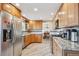 Well-lit kitchen featuring wood cabinets, stainless steel appliances, and granite countertops at 5733 S Killarney Way, Centennial, CO 80015