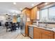 Well-lit kitchen with stainless steel appliances, wood cabinetry, granite countertops, and an open floor plan at 5733 S Killarney Way, Centennial, CO 80015