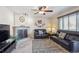 Relaxing living room featuring a fireplace, ceiling fan, plush seating, and natural light at 5733 S Killarney Way, Centennial, CO 80015