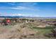 Scenic aerial view of a property surrounded by lush greenery, mountains, and a baseball field at 7835 Valley View St, Louviers, CO 80131