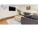 Comfortable finished basement featuring a grey sofa, ottoman, and a mounted television at 7835 Valley View St, Louviers, CO 80131