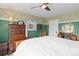 Bright bedroom featuring a floral wallpaper accent wall, ceiling fan, and wood-framed bed at 7835 Valley View St, Louviers, CO 80131