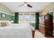 Cozy bedroom boasts floral wallpaper, hardwood floors, and a picturesque view from the large window at 7835 Valley View St, Louviers, CO 80131