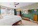 Inviting bedroom with hardwood floors, three windows, patterned wallpaper, and a ceiling fan at 7835 Valley View St, Louviers, CO 80131