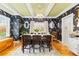 Formal dining room with dark bird-themed wallpaper, hardwood floors, and elegant chandelier at 7835 Valley View St, Louviers, CO 80131