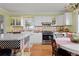 Charming kitchen with white cabinets, cake-themed backsplash, and marble island at 7835 Valley View St, Louviers, CO 80131
