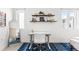 Brightly lit bedroom with hardwood shelves, an accent mirror, a desk, and a blue patterned rug at 2550 Lawrence St # Rb308, Denver, CO 80205
