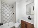 Modern bathroom with a geometric tiled shower, stylish vanity, and sleek black hardware at 11586 Chase Way, Westminster, CO 80020
