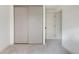 Vacant room with neutral paint and carpet, featuring sliding closet doors and access to hallway at 11586 Chase Way, Westminster, CO 80020