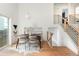 Bright dining room featuring modern table and chairs next to wooden stair case with horizontal bars at 11586 Chase Way, Westminster, CO 80020