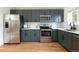 Well-lit kitchen with stainless steel appliances, green cabinets, white countertops, and light hardwood floors at 11586 Chase Way, Westminster, CO 80020