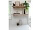 Detailed view of the kitchen backsplash, floating shelves, and decorative items near a window at 11586 Chase Way, Westminster, CO 80020