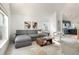 Comfortable living room with modern sofa, neutral decor, and access to the kitchen at 11586 Chase Way, Westminster, CO 80020