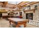 Inviting game room with pool table, wet bar, fireplace, and wood beam ceilings at 2 University Ln, Greenwood Village, CO 80121