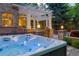Relaxing hot tub on a stone patio, surrounded by lush greenery and an outdoor seating area at 2 University Ln, Greenwood Village, CO 80121