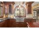 Kitchen features stone countertops and backsplash, stainless steel sink, and wood cabinets at 2 University Ln, Greenwood Village, CO 80121