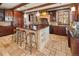 Spacious kitchen boasts an island, wood cabinets, stone floors and a stone range hood at 2 University Ln, Greenwood Village, CO 80121