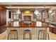 Kitchen boasts an island with chairs, wood cabinets, stone floors and beamed ceiling at 2 University Ln, Greenwood Village, CO 80121