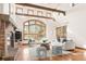 Bright living room with exposed beams, a grand window, brick fireplace, and hardwood floors at 2 University Ln, Greenwood Village, CO 80121
