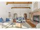 Open-concept living and dining area showcasing exposed beams, hardwood floors, and a brick fireplace at 2 University Ln, Greenwood Village, CO 80121