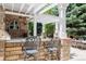 Covered outdoor kitchen and bar area perfect for entertaining with seating and stone accents at 2 University Ln, Greenwood Village, CO 80121