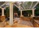 Outdoor stone patio with a fireplace, built-in grill, and pergola-covered dining area at 2 University Ln, Greenwood Village, CO 80121