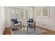 This sitting area showcases bright windows with custom shutter, natural light, and hardwood floors at 2 University Ln, Greenwood Village, CO 80121
