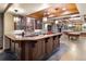 Entertainer's wet bar in finished basement with bar seating and game room area at 2 University Ln, Greenwood Village, CO 80121