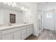 Bright bathroom with double sink vanity, glass shower, and wood-look floors at 19080 E 96Th Pl, Commerce City, CO 80022