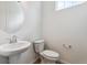 Clean powder room with pedestal sink and stylish round mirror at 19080 E 96Th Pl, Commerce City, CO 80022