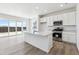 Modern kitchen with white cabinetry, stainless steel appliances, and large island at 19080 E 96Th Pl, Commerce City, CO 80022
