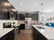 Modern kitchen with dark cabinets, stainless steel appliances, and quartz countertops at 5833 Alton St, Denver, CO 80238