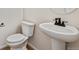 Clean and modern bathroom with pedestal sink and white toilet at 3242 Boral Owl Dr, Brighton, CO 80601