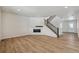 Living room with hardwood floors and a fireplace, open to kitchen at 3242 Boral Owl Dr, Brighton, CO 80601