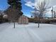 Snow-covered backyard with shed and two trees at 1851 S Perry Way, Denver, CO 80219