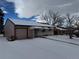 Ranch style home with attached garage and snow-covered front yard at 1851 S Perry Way, Denver, CO 80219