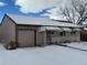 Ranch style home with attached garage and snow-covered front yard at 1851 S Perry Way, Denver, CO 80219