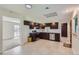 Modern kitchen featuring dark cabinetry, stainless steel appliances, and tile flooring at 1851 S Perry Way, Denver, CO 80219