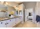 Well-lit bathroom features a granite countertop vanity, a walk-in shower and access to the main bedroom at 16364 Flintlock Ct, Parker, CO 80134