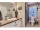 Neutral-toned bathroom with a mirror, a vanity with storage, and a shower behind a curtain at 16364 Flintlock Ct, Parker, CO 80134