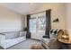 Comfortable bedroom featuring a crib, a gray chair, soft lighting and a gray curtain at 16364 Flintlock Ct, Parker, CO 80134