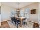 Dining room with modern chandelier, long wooden table and bright light from windows at 16364 Flintlock Ct, Parker, CO 80134