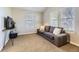 Comfortable living room with a brown couch, carpeted floor, and bright natural light from the windows at 16364 Flintlock Ct, Parker, CO 80134