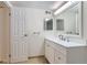 Bathroom with a white vanity, modern mirror, and a door, with updated fixtures and neutral tones at 3315 S Ammons St # 103, Lakewood, CO 80227