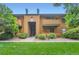 Inviting condo with wood facade, balconies, well-maintained landscaping, and a vibrant green lawn at 3315 S Ammons St # 103, Lakewood, CO 80227
