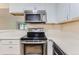 Modern kitchen features stainless steel appliances, white subway tile backsplash, and updated white cabinetry at 3315 S Ammons St # 103, Lakewood, CO 80227